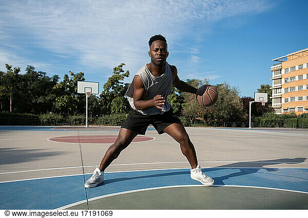 Afroamerikanischer Sportler dribbelt Basketball