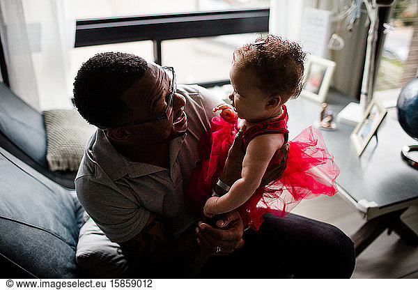 Afroamerikanischer Vater lächelt Biracial-Tochter an