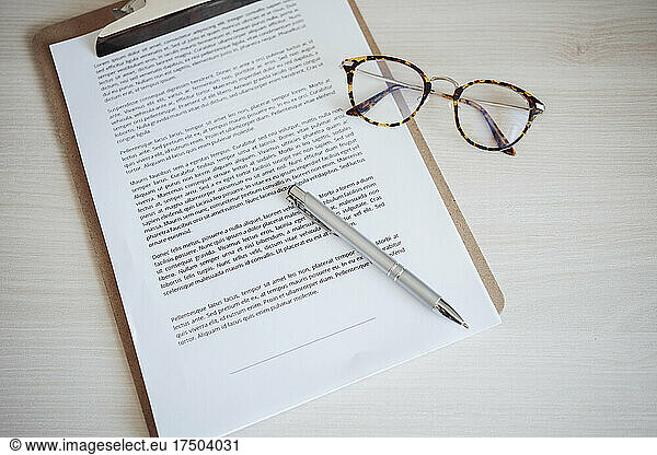 Agreement contract with pen and eyeglasses at office desk