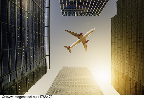 Airplane flying over highrise buildings  travel concept