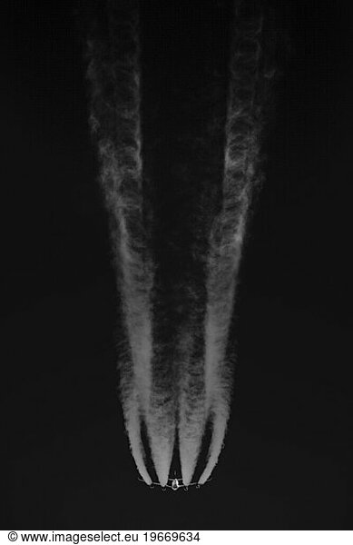 Airplane In Flight With Long Contrails From Below