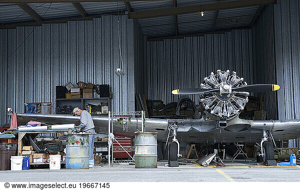 Airplane mechanic working on a vintage aircraft.