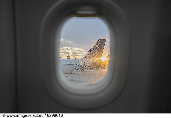 Airplane tail seen from behind window of adjacent aircraft