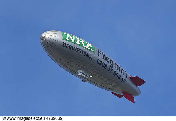 Airship  zeppelin with label of the NRZ Der Westen newspaper  Flieg Mit! against a blue sky