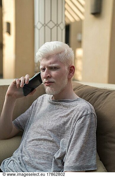 Albino man talking on the phone looking at camera