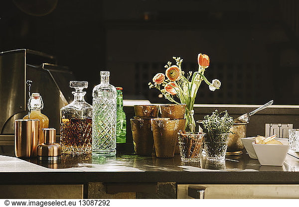 Alcohol bottles with flower vase on table