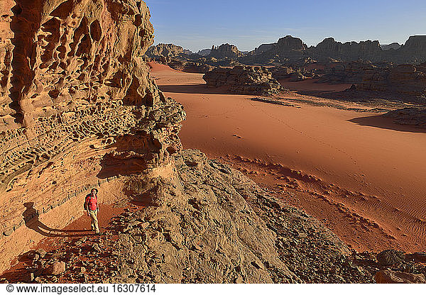 Algerien  Sahara  Tassili N'Ajjer Nationalpark  Tassili Tadrart  Frau beim Wandern in der felsigen Landschaft des Kars