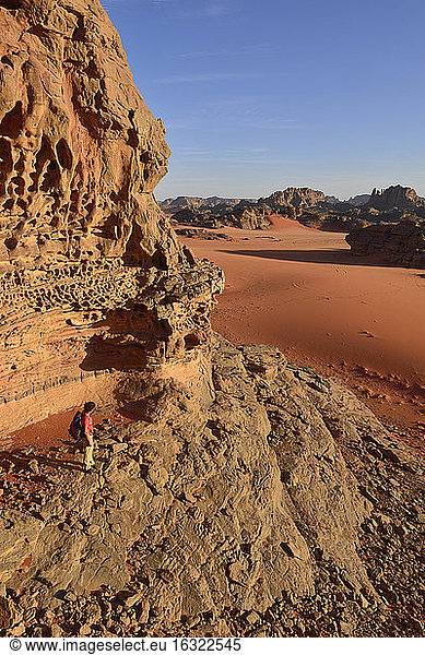 Algerien  Tassili n' Ajjer  Tadrart  Sahara  Tassili n' Ajjer National Park  Frau wandert in der Felslandschaft des Kessels