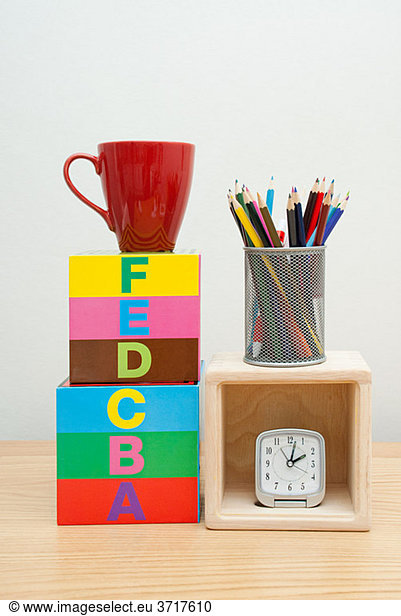 Alphabet blocks  mug  pencils and clock