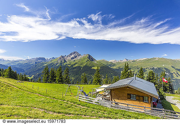 Alpine hut with Swiss flag beneath stunning clouds  Urses  Surselva  Graubunden  Switzerland  Europe