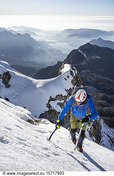 Alpinist ascending a snowy mountain  Orobie Alps  Lecco  Italy