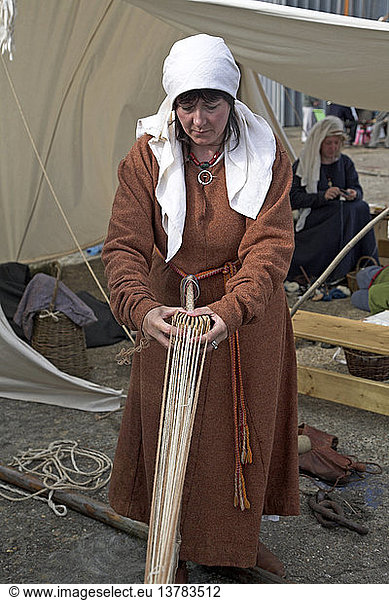 Als Wikingerin verkleidete Frau demonstriert den Prozess der Seilherstellung