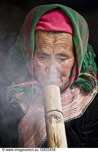 Alte Dame raucht Thuoc Lao  ein traditioneller vietnamesischer Brauch