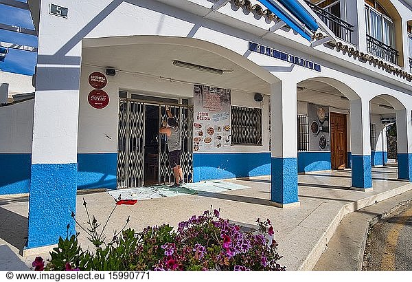 Altea La Vella  Alicante Spain  May 4th  2020  Corona crisis: A handyman is cleaning the entrance grille of a bar. On May 11th  phase 1 of the de-escalation plan of the Spanish government begins and restaurants are allowed for the first time since the alarm condition was set on March 14th open to the public  albeit with severe restrictions on the number of guests and strict hygiene requirements.