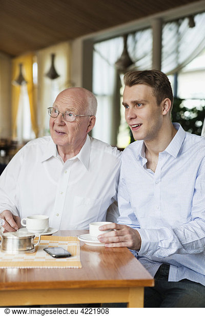 Alter Mann und junger Mann beim Kaffeetrinken