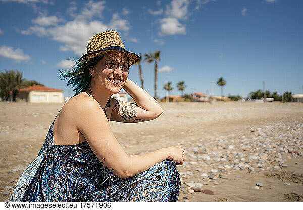 alternative female enjoying the sea breeze with her hat