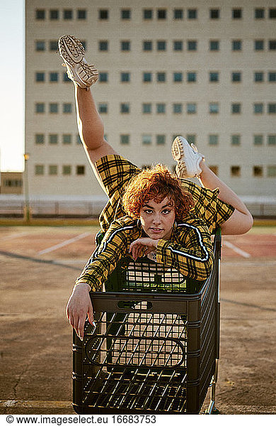 Alternative redhead with yellow shirt and a shopping cart