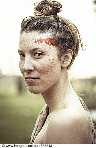 alternative young strong woman with tribal face paint
