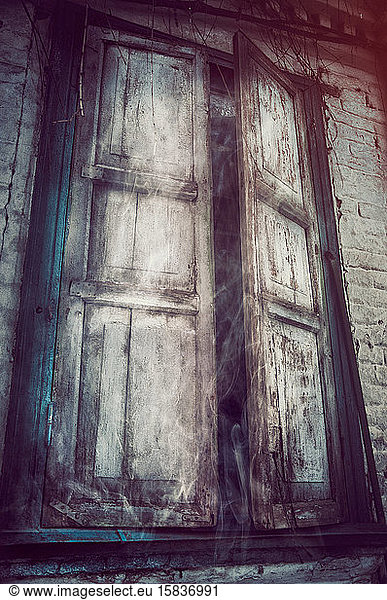 Altes Fenster in horizontaler Farbkomposition mit einer alten schmutzigen Wand.
