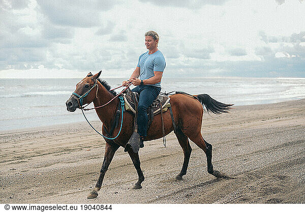 american beauty boy riding horse at the beach in Costa Rica