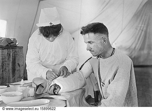 American Red Cross Nurse bandaging arm of Wounded American Soldier  American Military Hospital No. 5  a complete portable Tent Hospital supported by American Red Cross  Auteuil  France  Lewis Wickes Hine  American National Red Cross Photograph Collection  June 1918