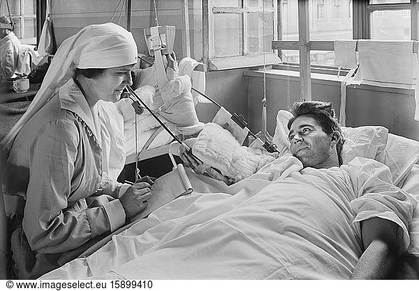American Red Cross Worker writing letter for American Soldier whose Right Arm is Disabled  Base Hospital 41  Saint Denis  France  Lewis Wickes Hine  American National Red Cross Photograph Collection  September 1918
