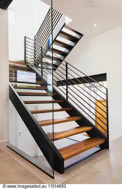 American walnut wood and black powder coated cold rolled steel stairs inside a modern cube style home  Quebec  Canada