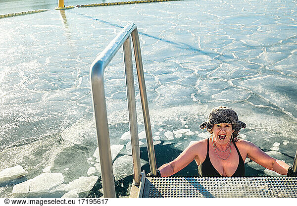 American Woman In Fur Hat Descending Ladder To Frozen Water In Denmark
