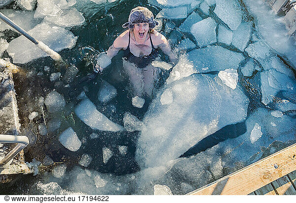 Amerikanische Frau Mitte 40  aufgeregt über das Schwimmen mit Eis in Dänemark
