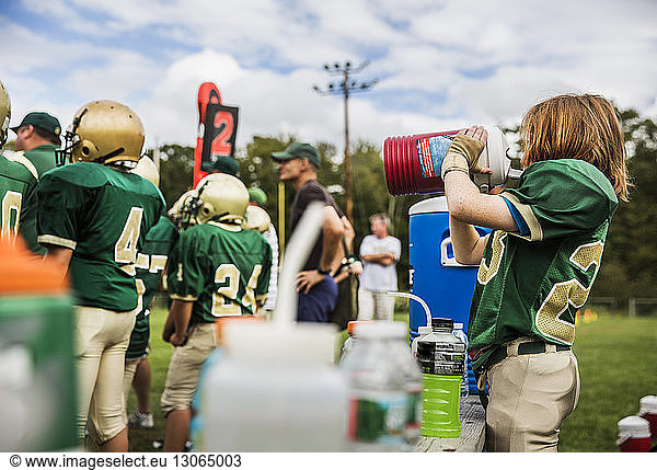 Amerikanischer Fussballspieler trinkt Wasser auf dem Spielfeld