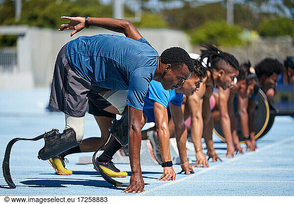 Amputierte Sprinter stehen an der Startlinie auf der sonnigen Sportbahn bereit