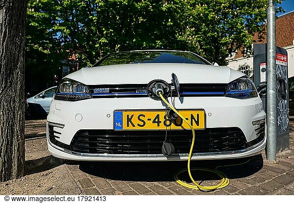 AMSTERDAM  NIEDERLANDE  8. MAI 2017: Volkswagen Golf GTE Benzin-Elektro-Hybridfahrzeug wird auf der Straße aufgeladen