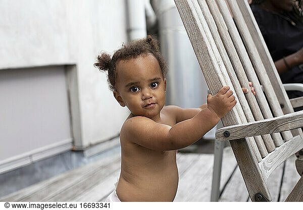An adorable female mixed race toddler looking into the camera