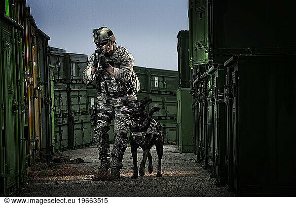 An Air Force Security Forces K-9 handler  and his military working dog  track an armed assailant through several shipping containers during combat operations training.