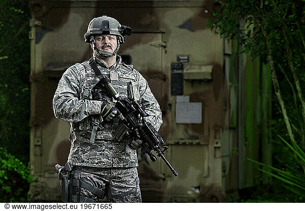 An Air Force Security Forces member patrols the area around a communications bunker during combat operations training.
