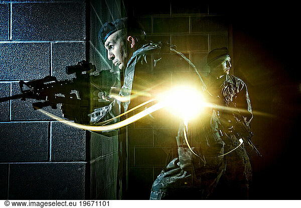 An Air Force Security Forces member tactically moves through the hallway of a dark building during clearing operations training.