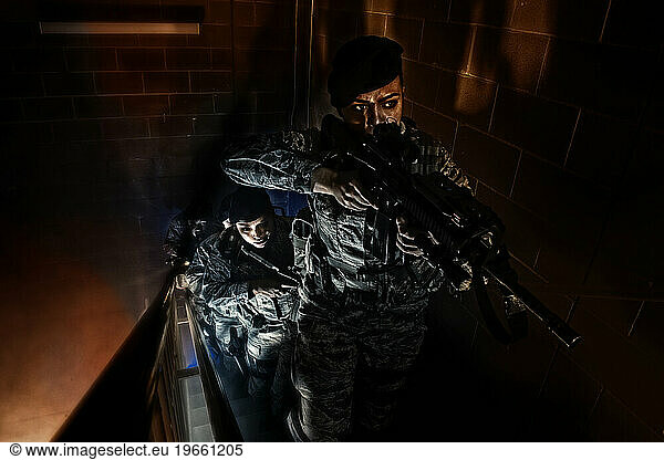 An Air Force Security Forces squad clear the stairwell of a training building during a simulated hostage situation.