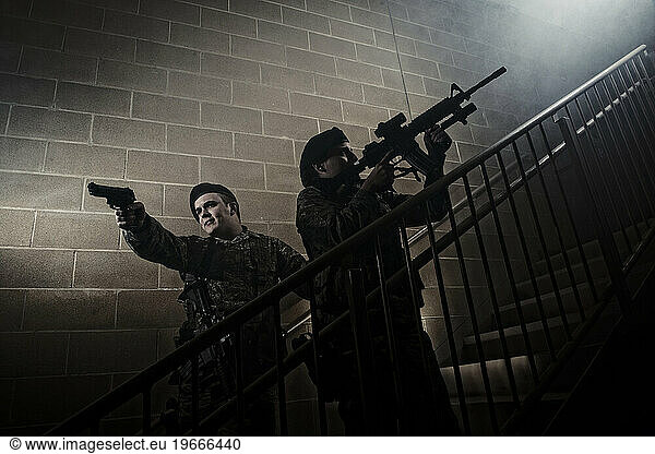 An Air Force Security Forces two-man team clear the stairwell of a training building during a simulated hostage situation.