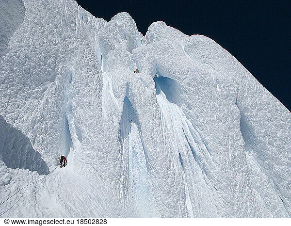 An alpinist climbs a snow 'mushroom'  crowning the summit of Cerro Torre's west ridge  during the first ever successful traverse of all four summits of the Torre Group  in Argentin