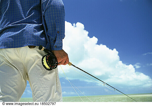 An anonymous fly-fisherman searches for a fish.