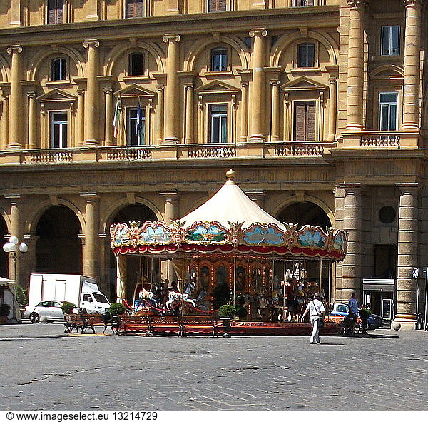 An antique carnival carousel in the middle of a plaza in Florence  Italy.