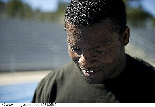 An athlete smiles after running sprints at track practice.