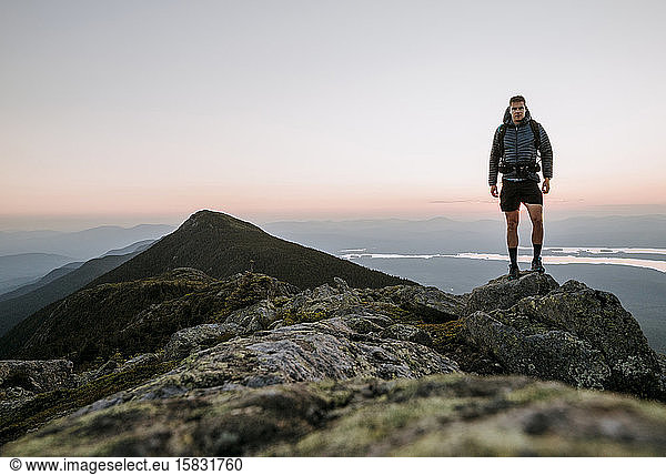 An athletic male hiker on the Appalachian Trail at sunset in Maine.