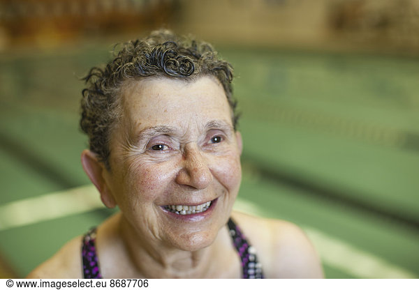An elderly woman in a swimming pool taking exercise.