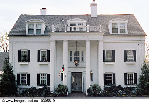 An elegant late 18th century mansion  facade with pillars and grand entrance. A hotel and restaurant.
