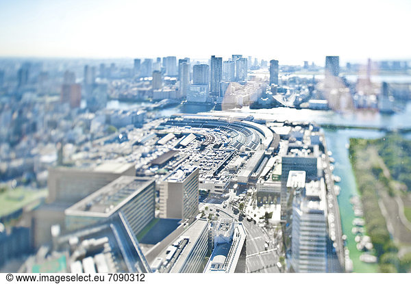 An elevated view of the downtown area of Tokyo. Buildings and boats moored on a canal.