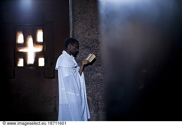 An Ethiopian Orthodox Christian man reads from scripture inside Bet Medhane Alem  Lalibela  Northern Ethiopia.