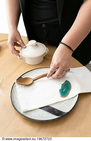 An interior designer styles a modern table setting