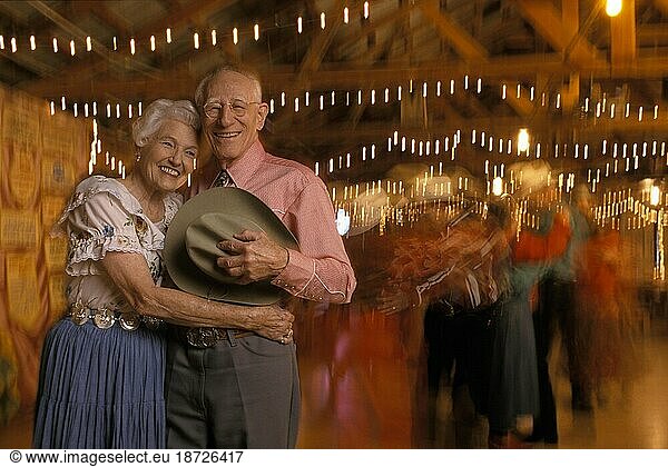 An older couple poses as they enjoy the evening cowboy dance in Texas.