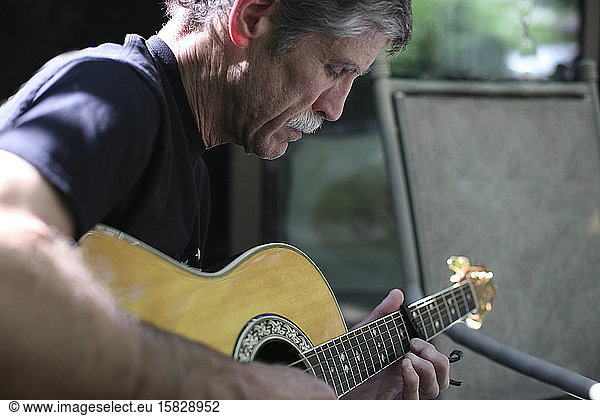 An older man playing guitar.